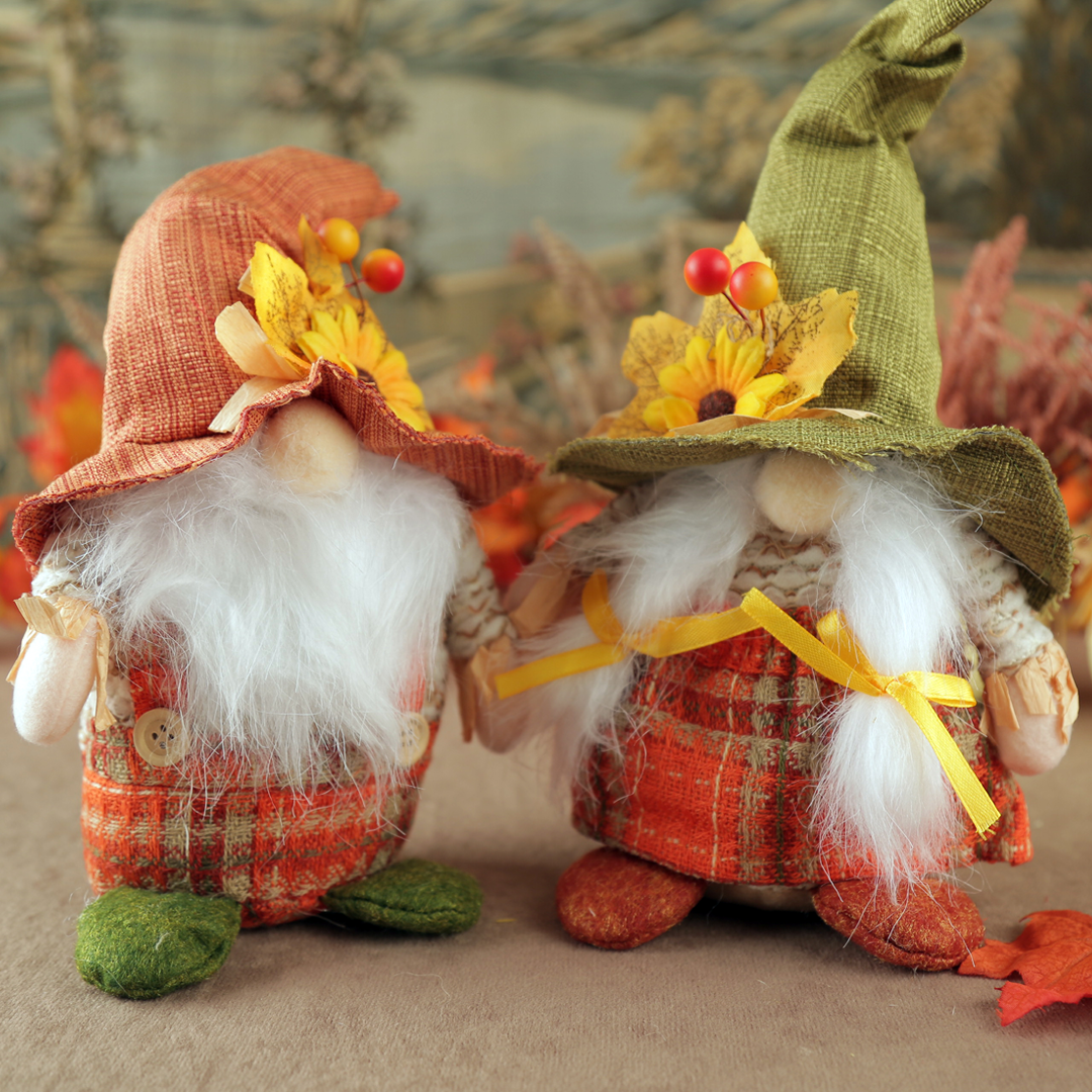Two autumn-themed gnomes with plaid outfits and colorful hats on a neutral background.