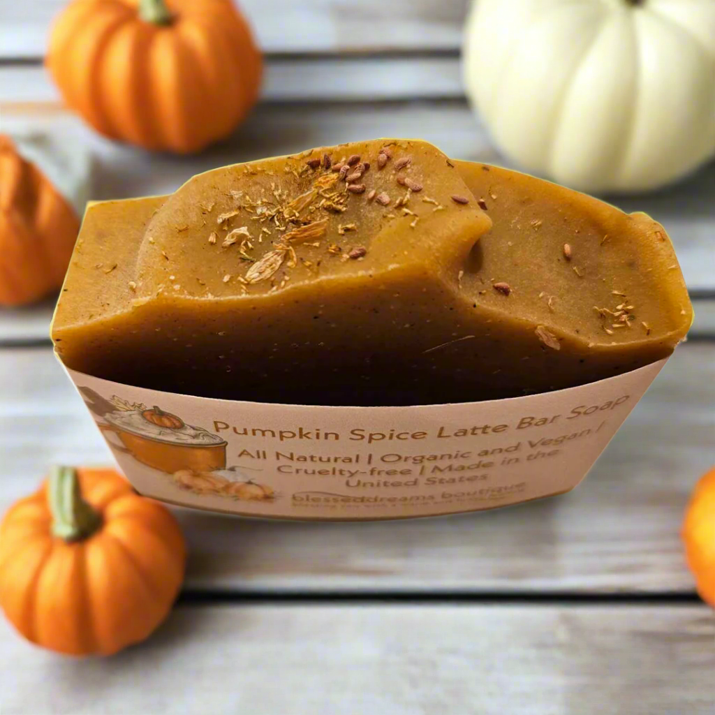 Pumpkin Spice Latte bar soap in a container with pumpkins around on a wooden surface