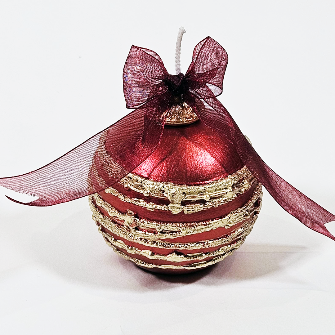 A Red Scented Wax Baubles Ornament with horizontal gold glitter stripes and a sheer dark red ribbon bow on top, photographed on a plain white background.