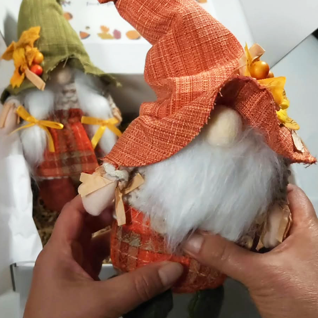 A small autumn-themed boy gnome figurine with a green burlap hat, white fluffy beard, and red patterned clothing, inside Gathered in Gratitude Thanksgiving gift box