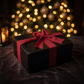 A black rectangular gift box tied with a wide red satin ribbon and bow.