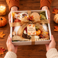 The Gathered in Gratitude Thanksgiving gift box being presented as a gift