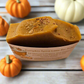 Pumpkin Spice Latte bar soap in a container with pumpkins around on a wooden surface
