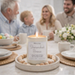 Candle labeled 'Shenandoah Breeze' on a table with a family in the background