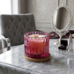 A pink gradient cut-glass candle jar with a wooden wick, sitting on a cork coaster on a marble table next to a silver vanity mirror.
Velvet Rose Musk-7oz posh candle vessel & lid - translucent mauve_al3