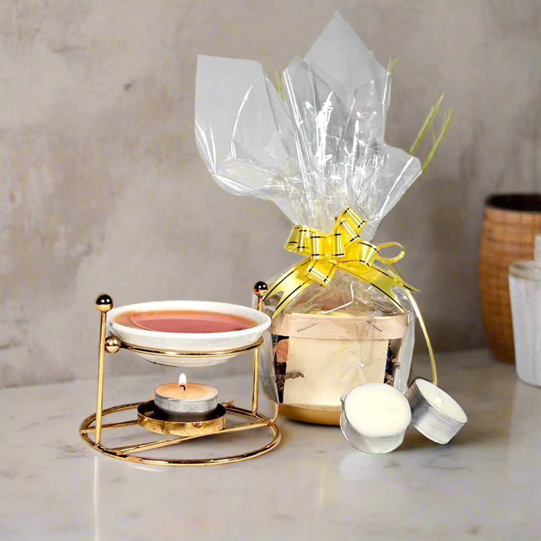 Candle warmer with tea candle and wrapped gift on a marble surface