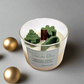 Yuletide Bliss - Wood Wick Soy Candle with green tree, cane and snowflake christmas decor on top of the candle.