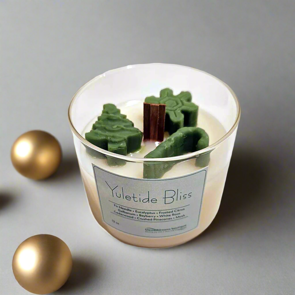 Yuletide Bliss - Wood Wick Soy Candle with green tree, cane and snowflake christmas decor on top of the candle.